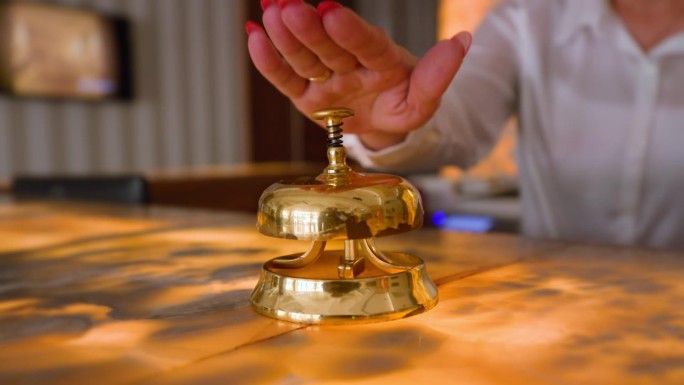 一位女士的手按了按酒店的接待铃。