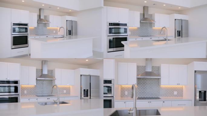 令人惊叹的厨房内饰在新的豪华房子，空石台面和集成水槽。白色光滑的橱柜，内置现代不锈钢电器