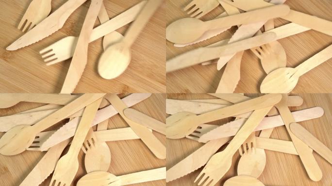 木质环保一次性餐具掉在桌子上。砧板上堆放着一堆木勺、刀叉。厨房、餐厅一次性生态餐具