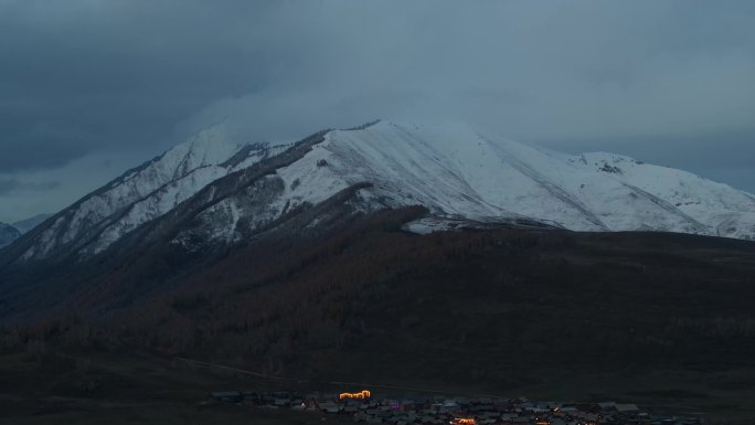 航拍新疆阿勒泰雪山下的禾木村夜景