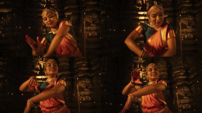年轻的印度妇女穿着传统的彩色纱丽，在寺庙里优雅地表演婆罗塔那提姆舞。这张低角度照片捕捉到了她凝视地平