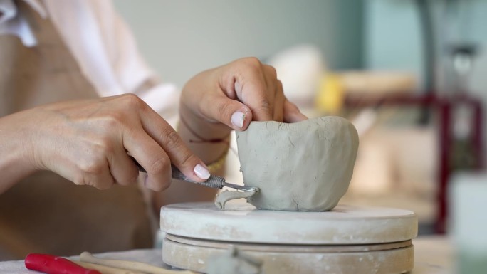 手工陶瓷作坊里陶土成型的过程，陶艺作坊里的妇女在陶艺作坊里塑造陶艺