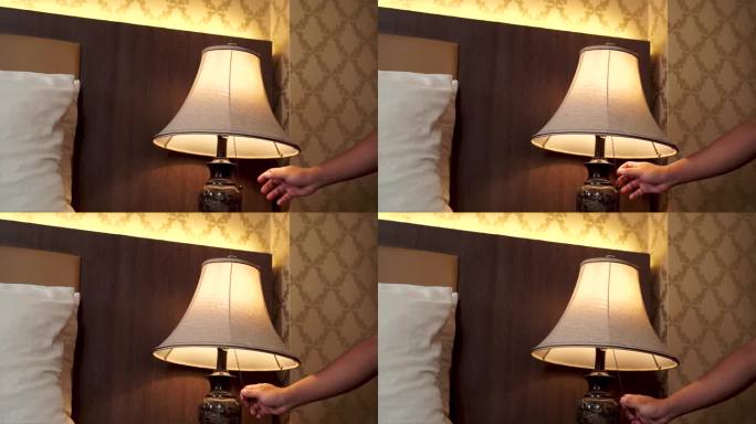 在舒适的卧室里用手打开和关闭一盏灯。关掉落地灯。