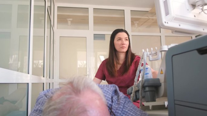 一位女医生用超声波给病人的膝盖拍x光片。腿部的治疗