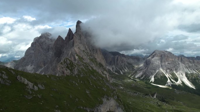 意大利白云岩中的塞达山脉，云层覆盖着陡峭的尖顶状悬崖。史诗航拍与无人机小车向后，近距离观察在意大利阿