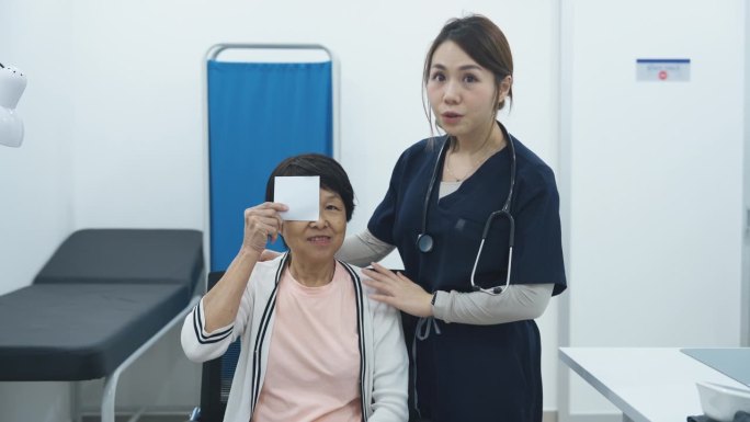 亚洲华裔女医生在诊所用视觉测试矢量图为老年患者做视力检查