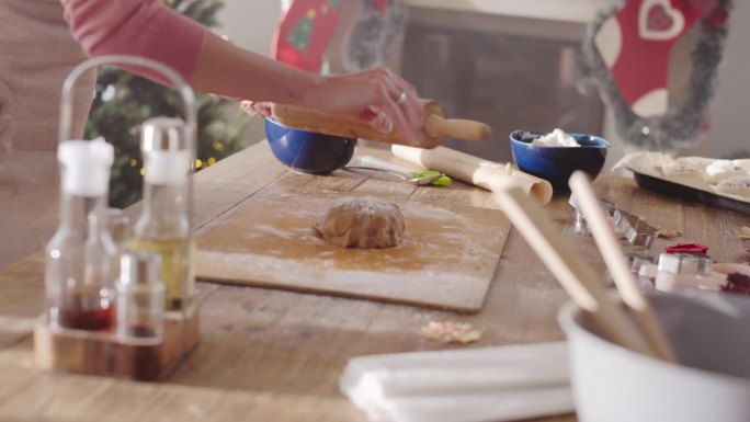 匿名女性在家里为圣诞节制作姜饼饼干准备面团的特写。家庭主妇在节日晚餐上制作糕点与家人和朋友分享