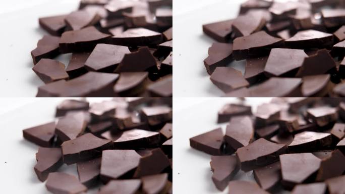 黑巧克力碎块放在陶瓷盘子表面。近距离观察烘焙原料。旋转