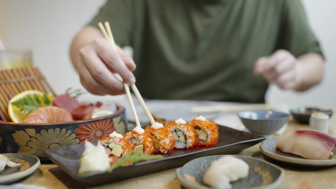 在日本餐厅的午餐时间，一个身材魁梧的男人给他的同事一个加利福尼亚maki卷的中镜头