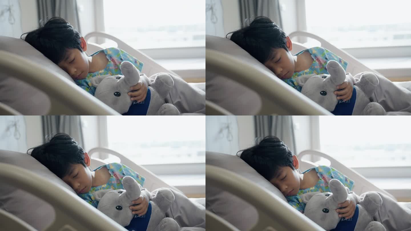 医院里，一个小病人抱着一个娃娃睡在床上。