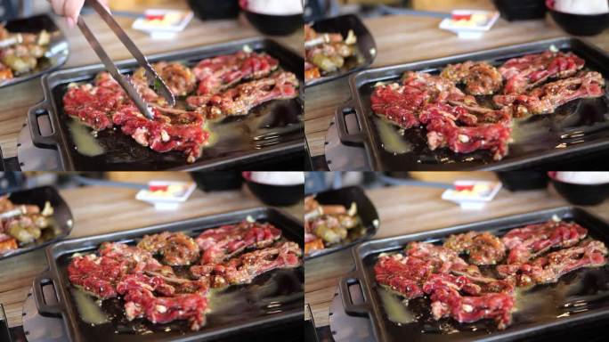 日本美食美味的日式涮锅和烧烤盘或烧烤盘。火锅涮的特写，用筷子夹肉、牛肉片放入火锅锅中烹煮。