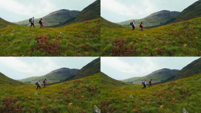 两个人一起用北欧拐杖徒步旅行。爬上一个巨大的岩田