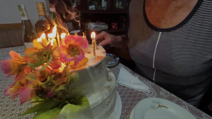 老女人吹灭生日蛋糕上的蜡烛