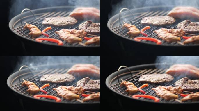 烧烤架的慢动作镜头，有牛排、鸡肉串、辣椒和鲑鱼