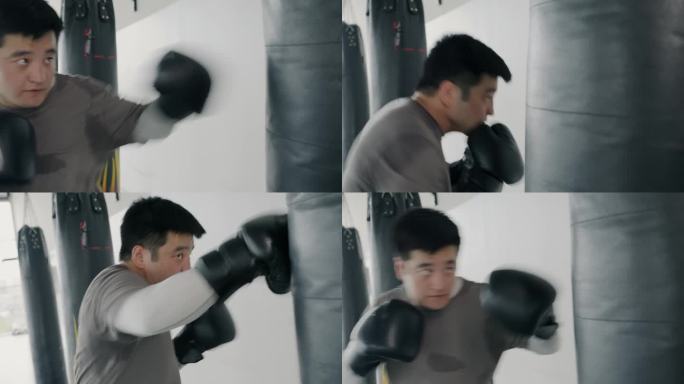 慢动作，强大的亚洲男子训练与拳击袋殴打它与拳击手套在健身房锻炼