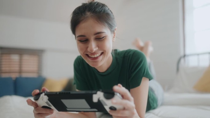 数字娱乐的乐趣:不同的女人在家里玩无线视频游戏。