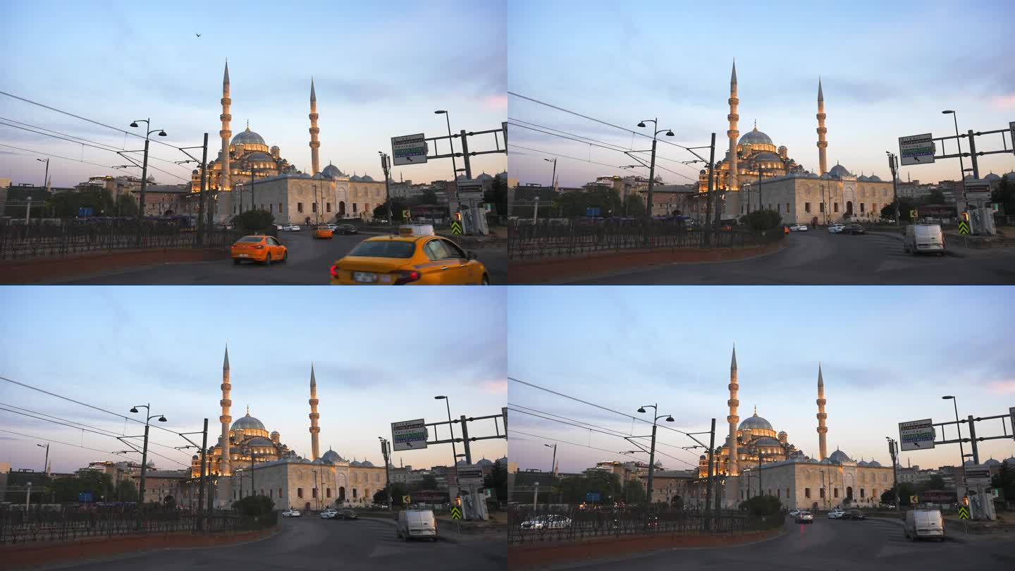 夕阳下的新瓦利德苏丹清真寺。汽车和出租车从加拉塔大桥驶出。土耳其伊斯坦布尔