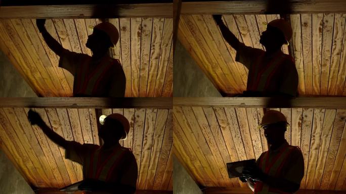 木匠在家里的天花板上填补缝隙的剪影。