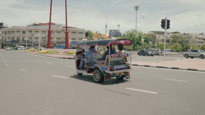 愉快的游客在曼谷享受当地出租车之旅。微笑的游客乘坐出租车发现曼谷充满活力的街道。