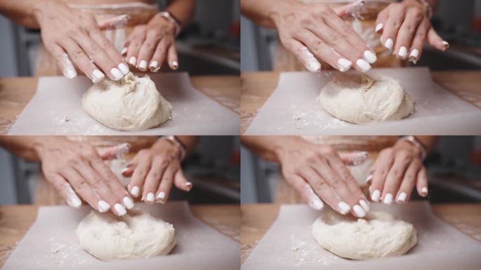 一个女人用慢镜头把面粉撒在烤纸上的面团上，然后把它弄光滑。