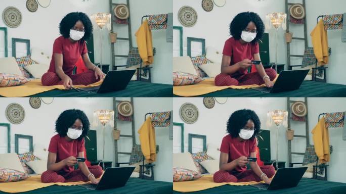 一名戴着口罩的非洲妇女正在网上购物
