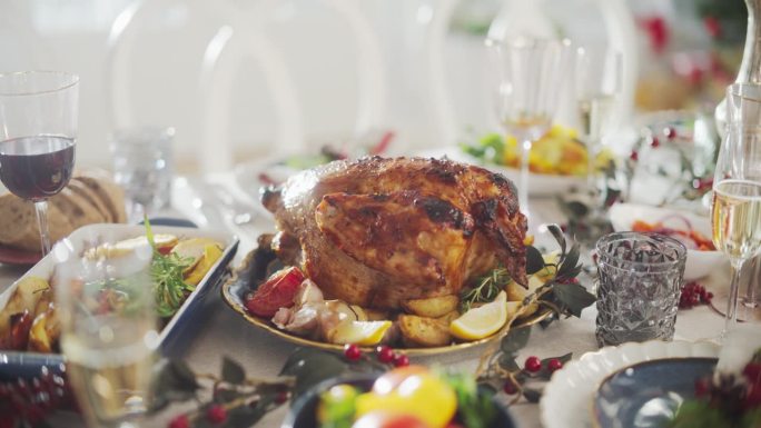 美味的特写火鸡与烤土豆在节日餐桌上。美味的饭菜和节日装饰准备家庭晚餐在家里庆祝感恩节或圣诞节