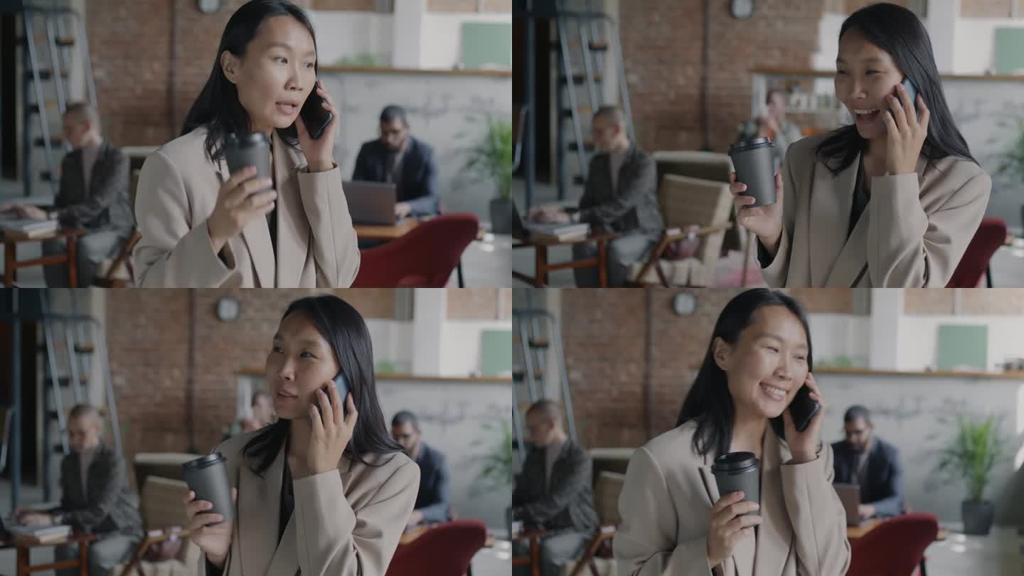 年轻的亚洲女商人站在联合办公中心一边打电话一边喝咖啡