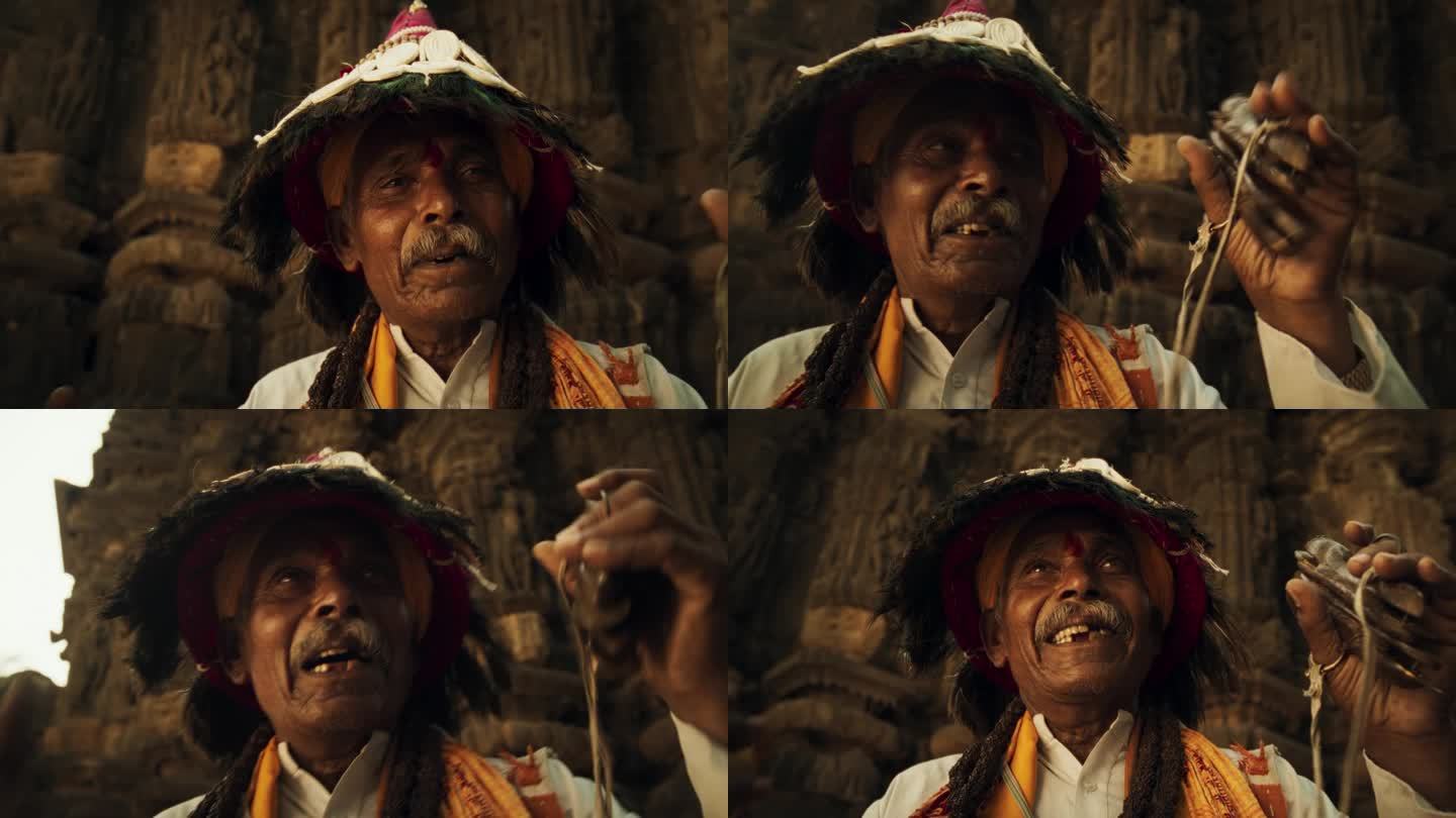 一位身着传统服装的印度老人在古老的印度寺庙里演奏乐器和诵经的特写肖像。老爷子用宗教音乐弘扬丰富的文化