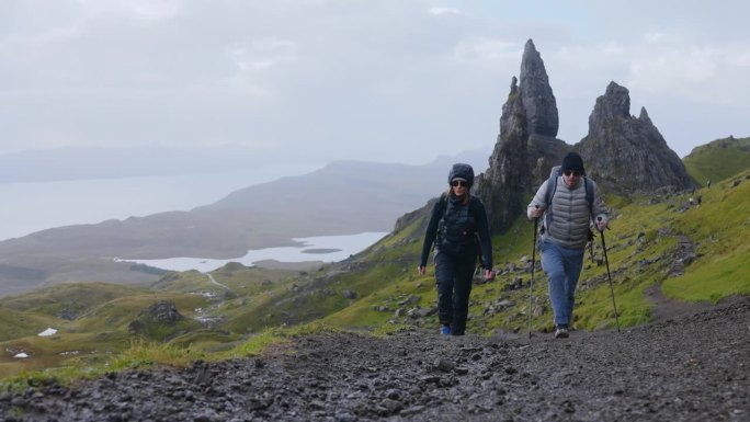 两个人一起用北欧拐杖徒步旅行。沿着小径走