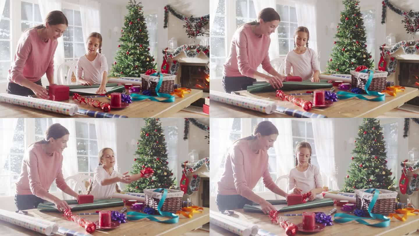 母亲和女儿在家里包装圣诞礼物的肖像。可爱的小女孩为送给家人的礼品盒挑选装饰品。充满爱和分享的节日