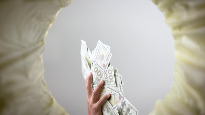 美钞落入废纸篓的超级慢动作镜头。