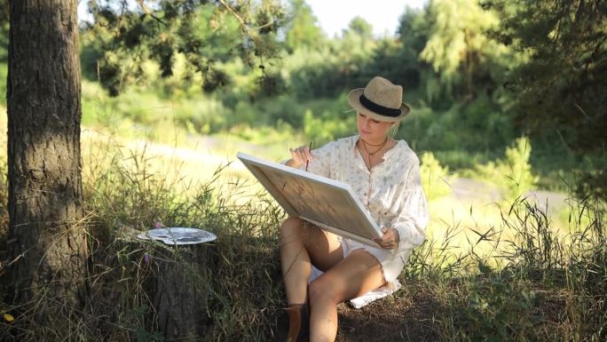 一位女艺术家在日落时作画。艺术家，待售艺术品，大自然的灵感