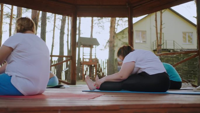 大体型女性在瑜伽营训练，健康的生活方式和运动减肥