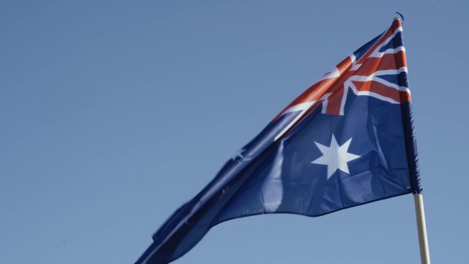 澳大利亚的国旗，在蓝天的映衬下展开。