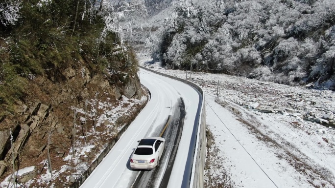 奔驰小轿车在雪地公路行驶旅行航拍雪景雾凇