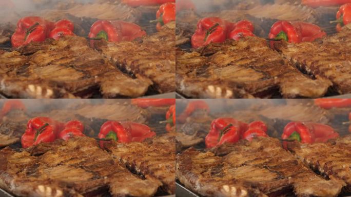 在燃烧的煤上烤肉。烤蔬菜。特写镜头。烤排骨和多汁的大红辣椒在木炭上烤着。烧烤食物，烧烤，烧烤。