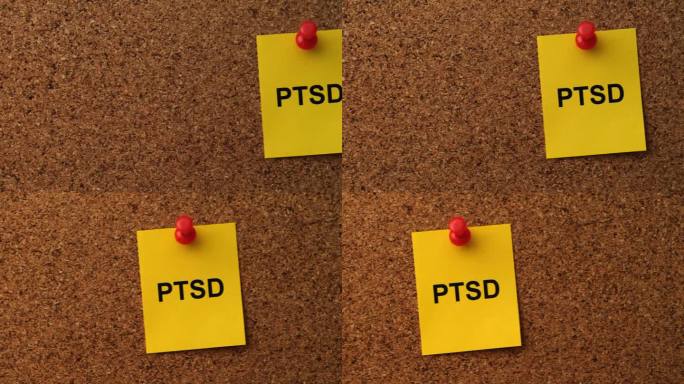 一张黄色的纸条，上面写着PTSD(创伤后应激障碍)的缩写，别在一块软木板上。关闭了。
