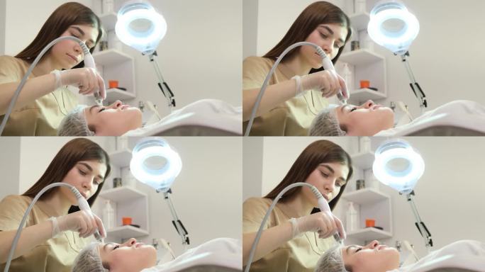 美容师在一位女士的脸上进行针疗。复兴的过程。