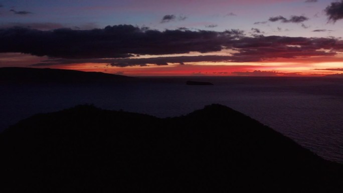 在夏威夷毛伊岛，黄昏时分，在一个火山火山口后面的航拍广角镜头，背景是神圣的卡奥拉维岛和莫洛基尼岛。4