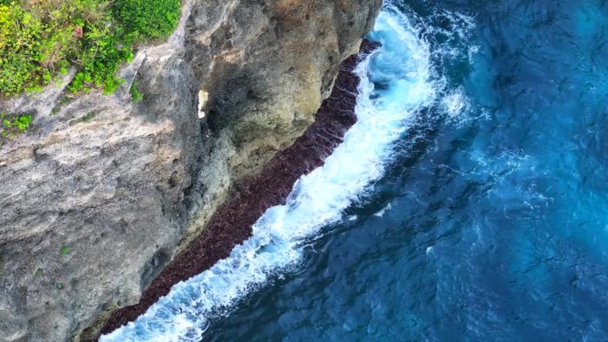 鸟瞰特写镜头，海浪冲击着印尼巴厘岛努沙佩尼达岛沿岸的岩石