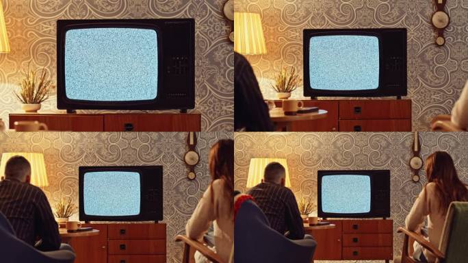 一台旧电视屏幕上的噪音和一对夫妇坐在客厅里