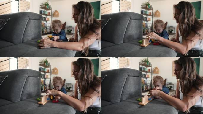 小女孩和妈妈在沙发上玩木制玩具
