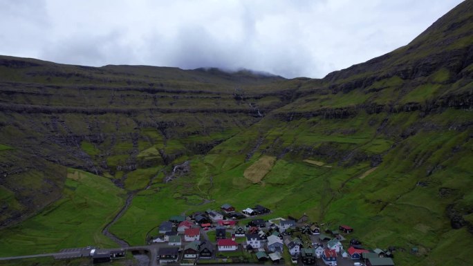 无人机在特约努维克上空缓慢飞行，向火山山峰飞去