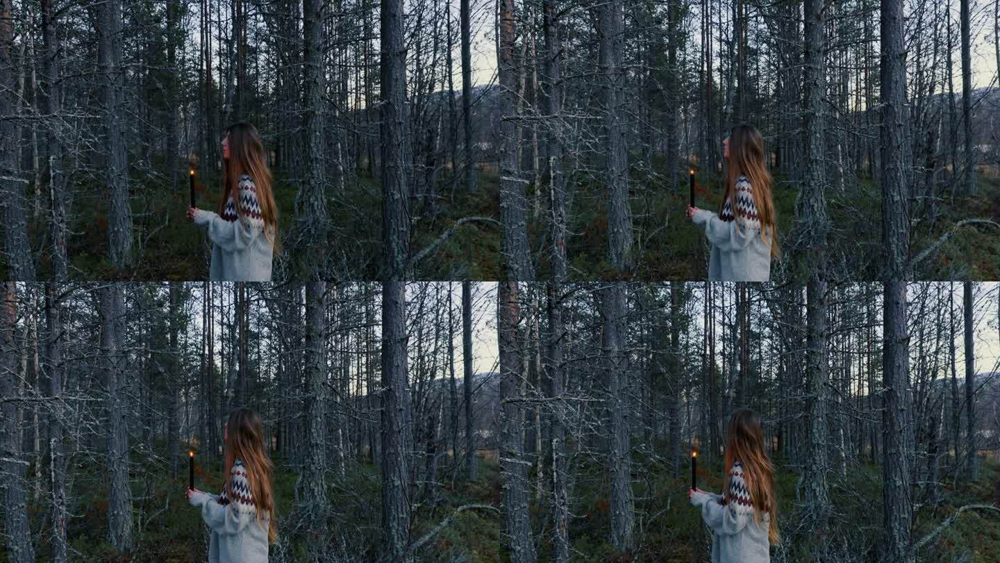 一个女人手拿蜡烛走在黑暗的挪威森林里