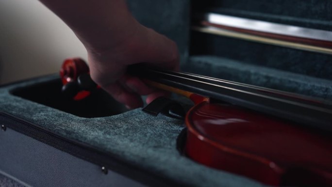 有光泽清漆的木制小提琴，用手从箱子里拿出来。古典原声音乐愉悦灵魂