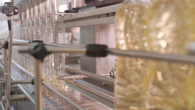 葵花籽油在生产线上的瓶身移动。葵花籽油装瓶生产线。植物油生产厂。高技术。工业背景