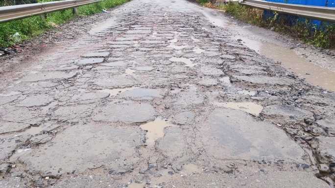 汽车开过坑洼道路泥巴路汽车通过坑洼道路