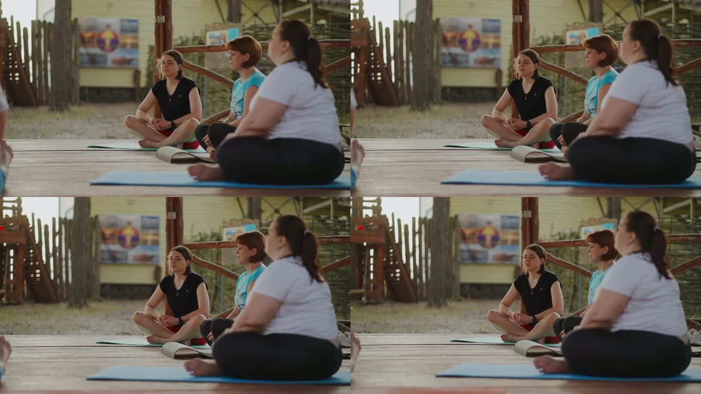 一群身材高大的女性在练习瑜伽，坐莲花位和冥想