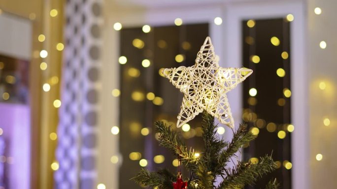 在家里的房间里，白色的藤星装饰着圣诞树的顶部，静态拍摄。