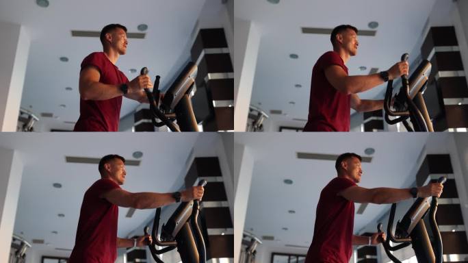 在健身房有氧区，一名男子正在椭圆机上训练